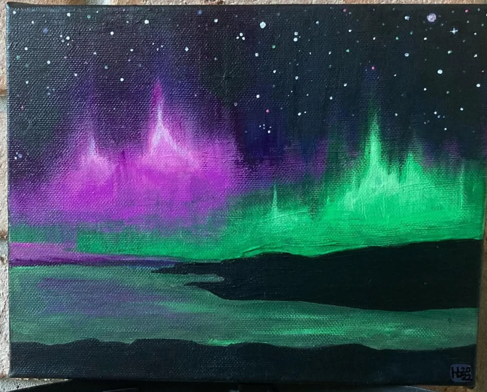 Mull. A purple and green aurora over dark water.