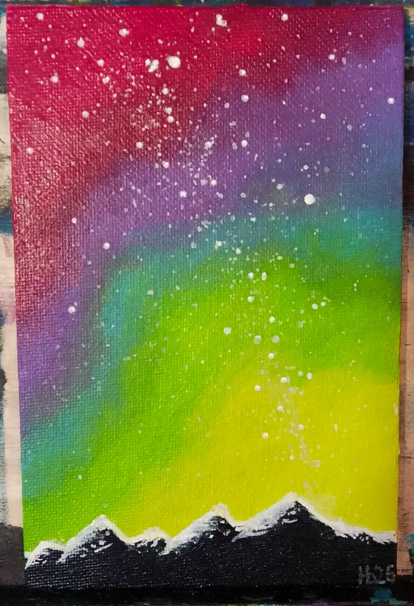Rainbow Aurora. A rainbow aurora pours from magenta through green and gold over snow-capped peaks.